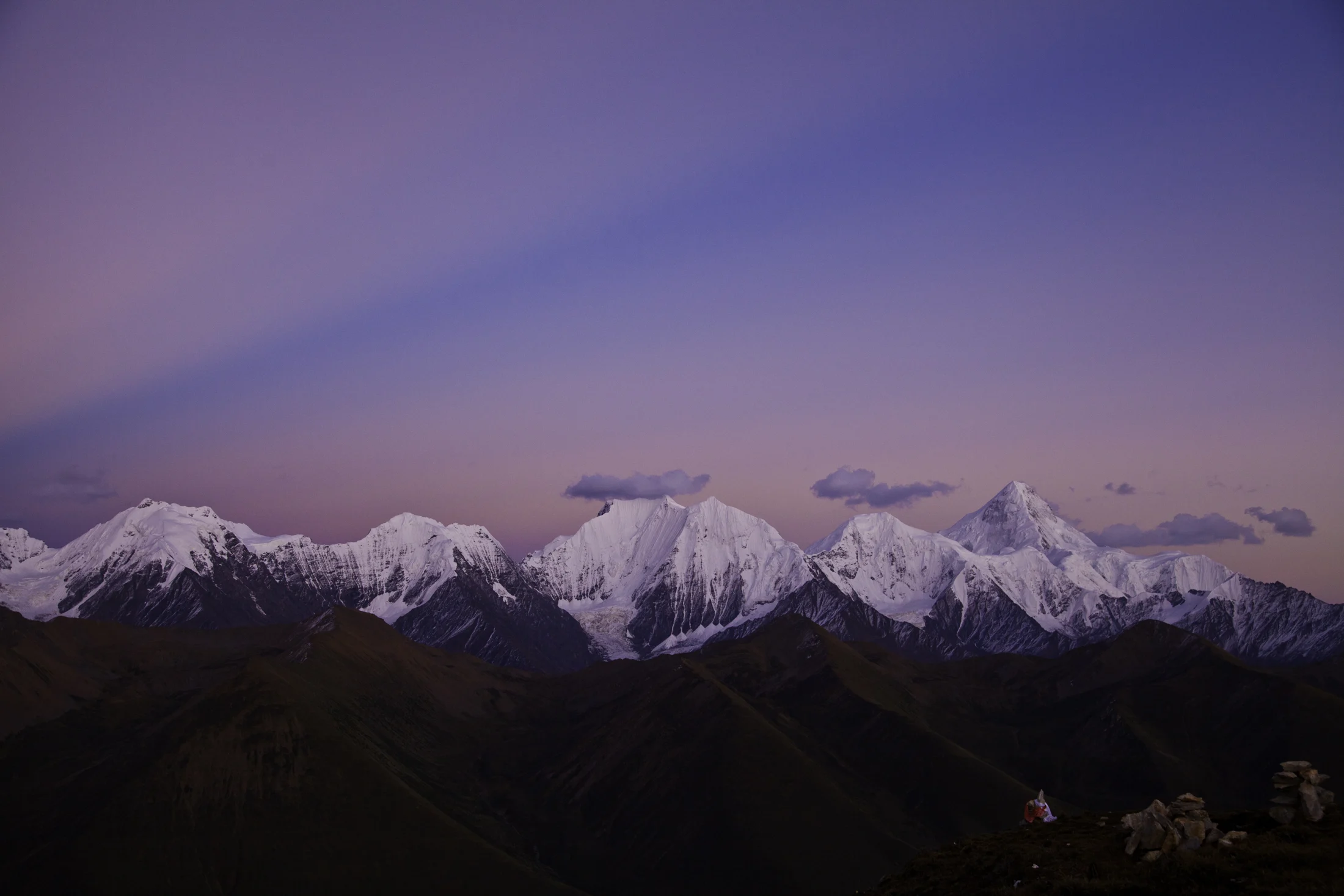 Snowy mountain peaks under a violet sky